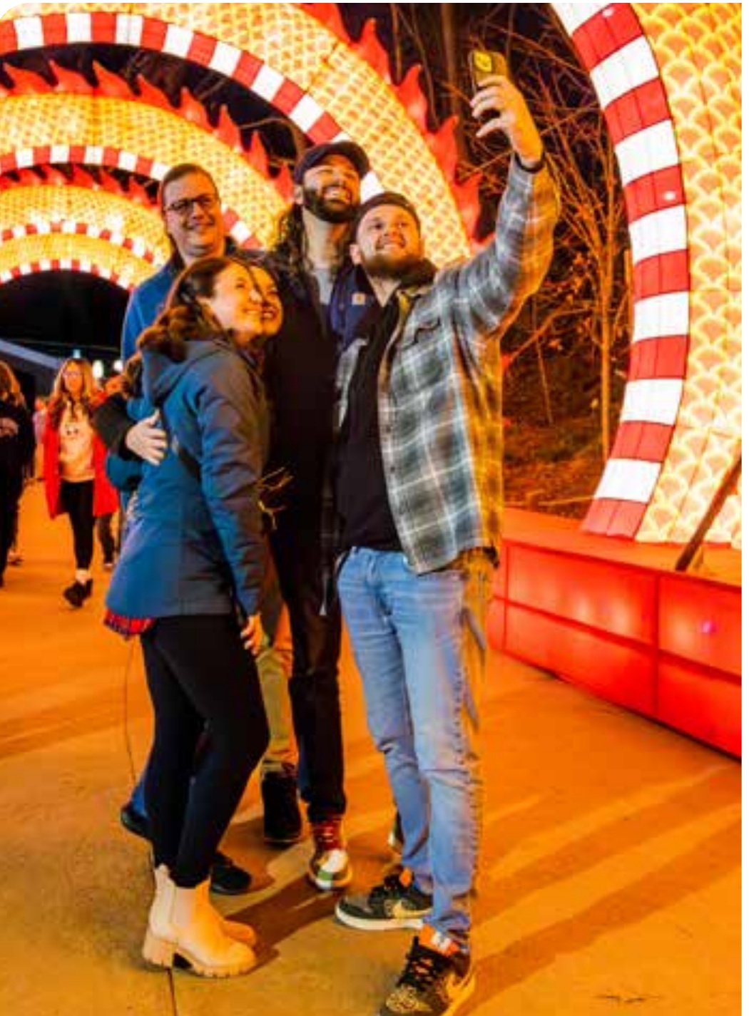 Guests taking a selfie inside a dragon-shaped lantern tunnel at the 2024 Grand Rapids Lantern Festival