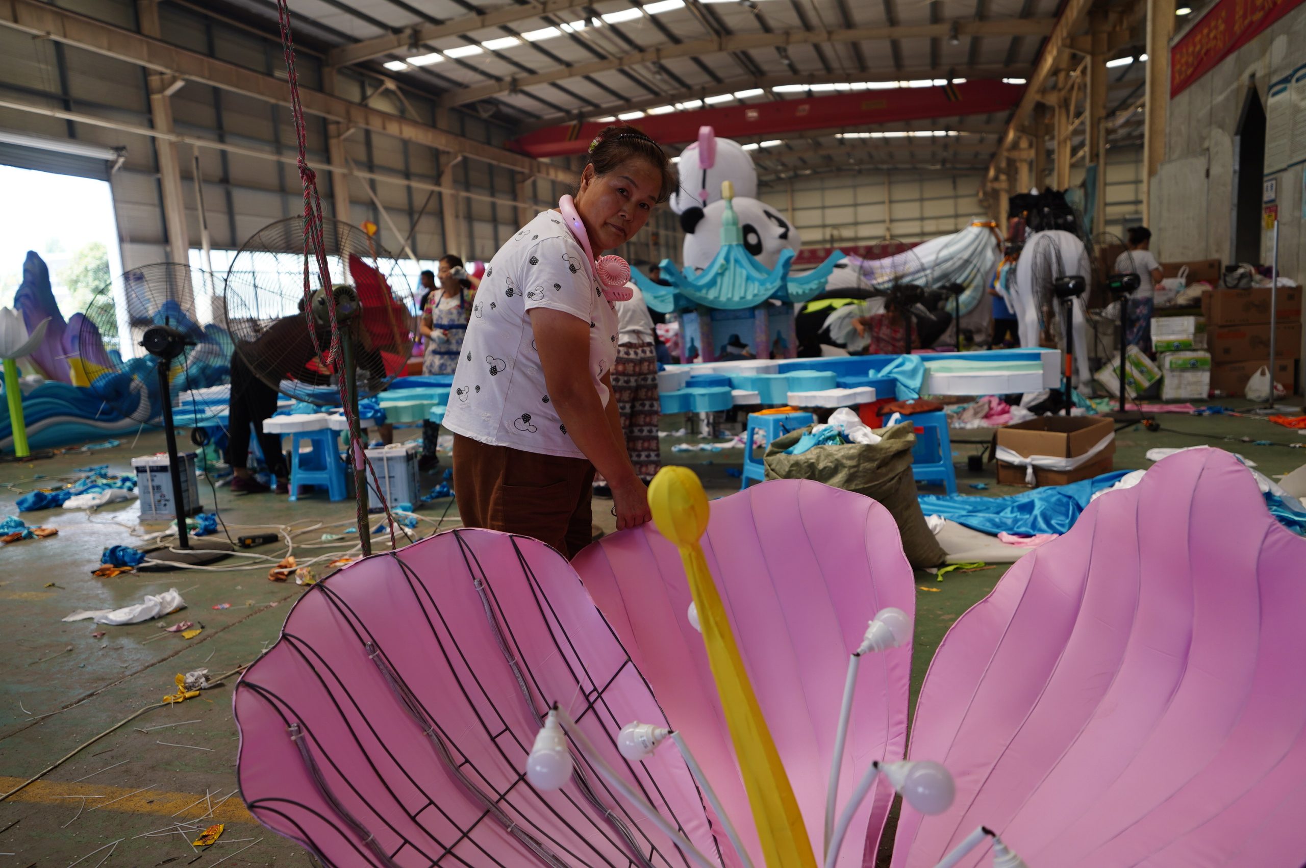 Craftsperson fitting fabric to large flower lantern petals